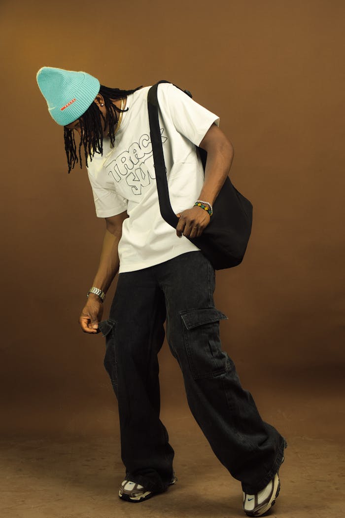 Urban streetwear fashion with a beanie, oversized pants, and a casual pose.